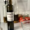 Murataj & Son Extra Virgin Olive Oil 250ml bottle on kitchen counter with tomatoes and glass bowl